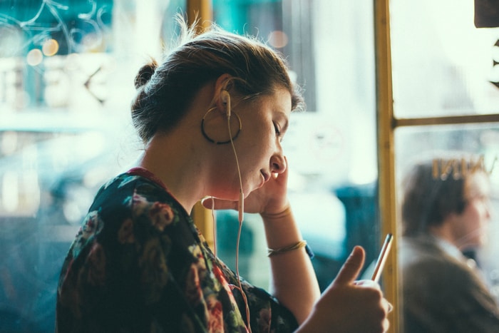 woman listening using white earphones